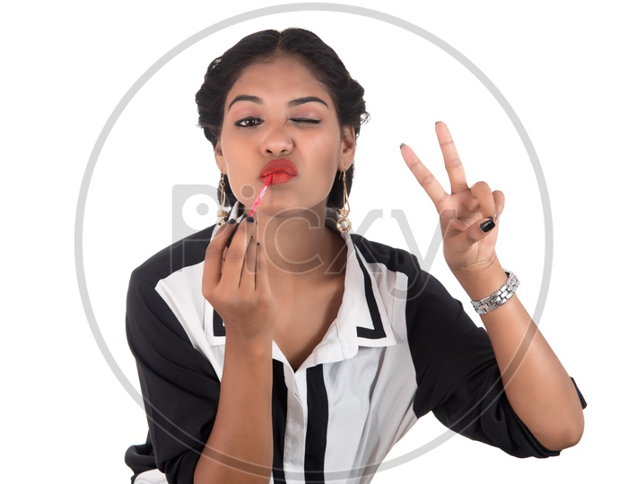 Young Indian Girl Putting On Lipstick with a Expression And Posing on White Background