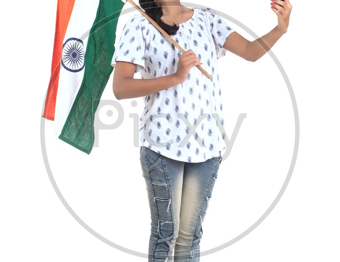 Young Indian Girl Holding Indian national Flag or Tri color Flag in hands And taking Selfie With Smart Phone  Over a White Background