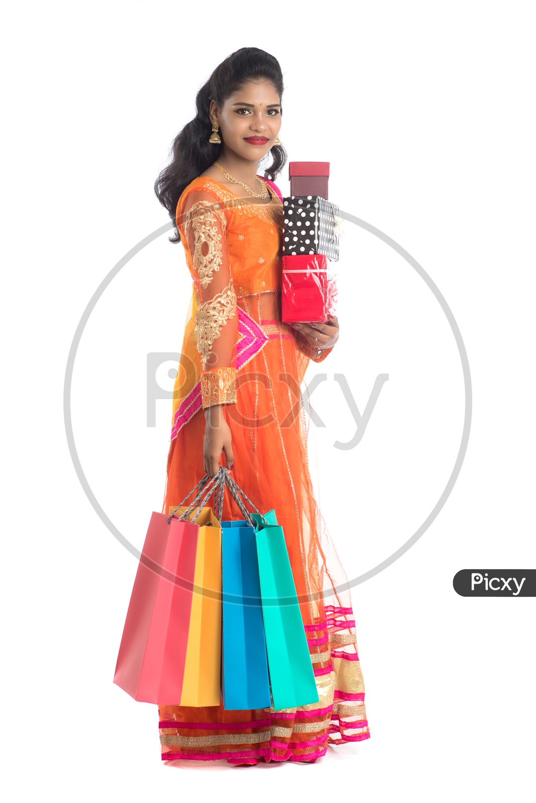 Young Traditional Indian Woman Holding Gift Boxes In hand With a Smile Face On an Isolated White Background