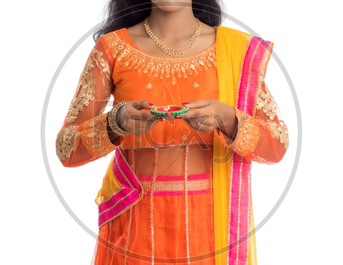 A young traditional smiling pretty Indian woman holding diya in hand