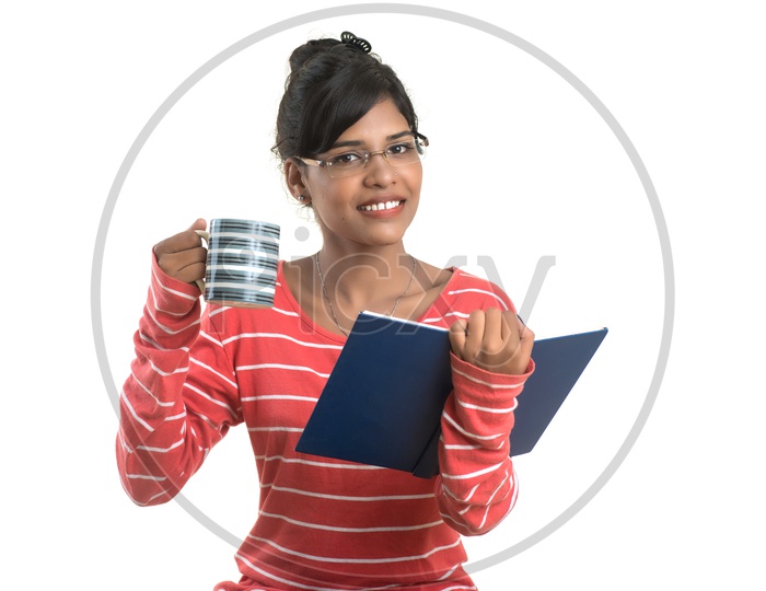 Pretty Young Girl Student Holding Book and With a Cup Of Coffee or Tea with an expression on face   and  Posing on an isolated White Background