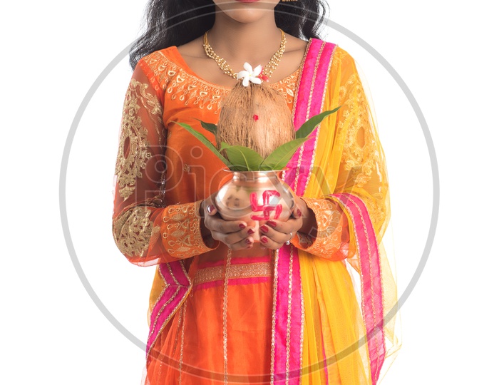 A Young Traditional Indian Woman Holding  Copper  Kalash In Hand and Posing Over a White Isolated Background