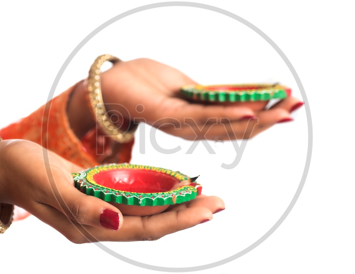 A young Indian woman holding diyas in hand