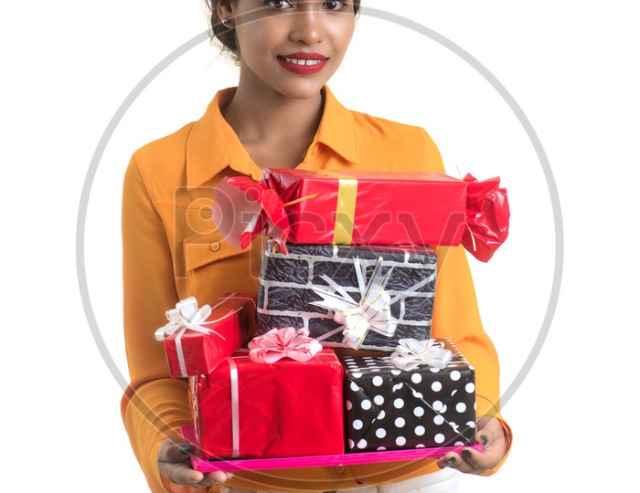 A Pretty Young Indian Girl With Gift Boxes Holding In Hand On an Isolated White Background