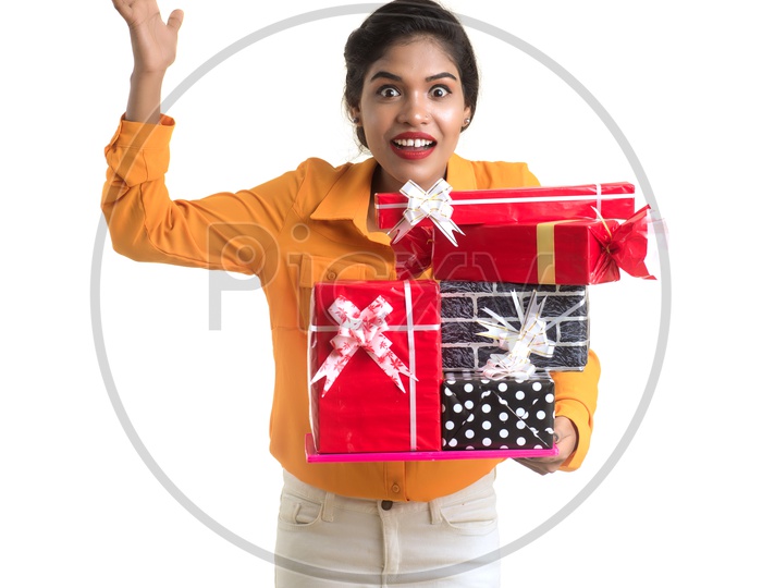 A Happy Young Beautiful Indian Girl Holding Gift Box in Hand on an Isolated White Background
