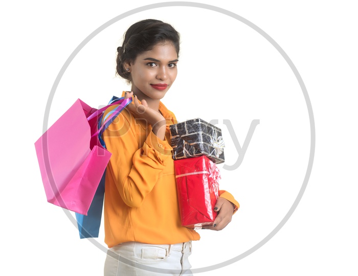 Young Girl Holding Gift Boxes and Bags in Hand  with Smile On her Face On an Isolated White Background