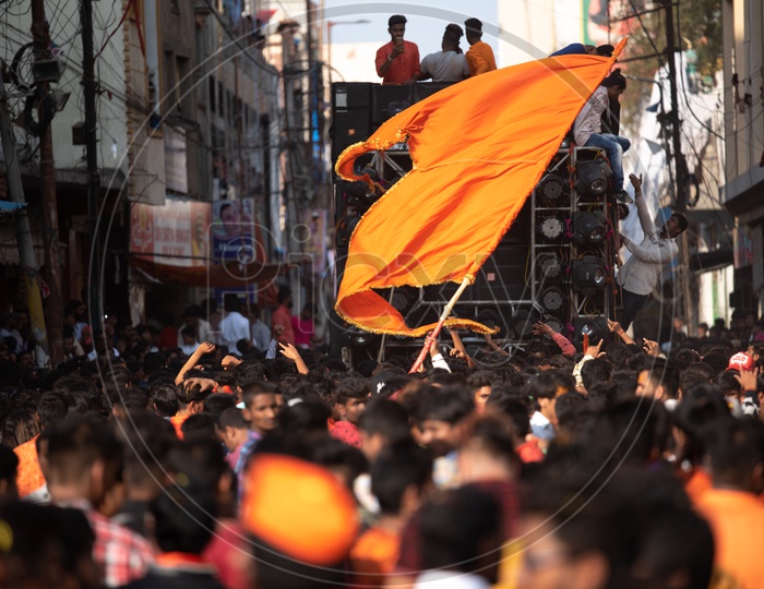 A man holding a Saffron flag in a crowd at Shri Rama Shobha yatra in Hyderabad