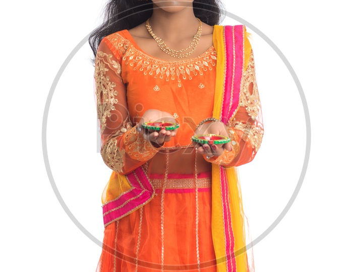A young traditional pretty Indian woman holding diyas in hand