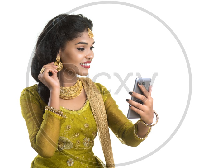Traditional Young Indian Girl Making Video Call On Her Smart Phone and With Smile Face And Showing Ornaments   On an Isolated White Background