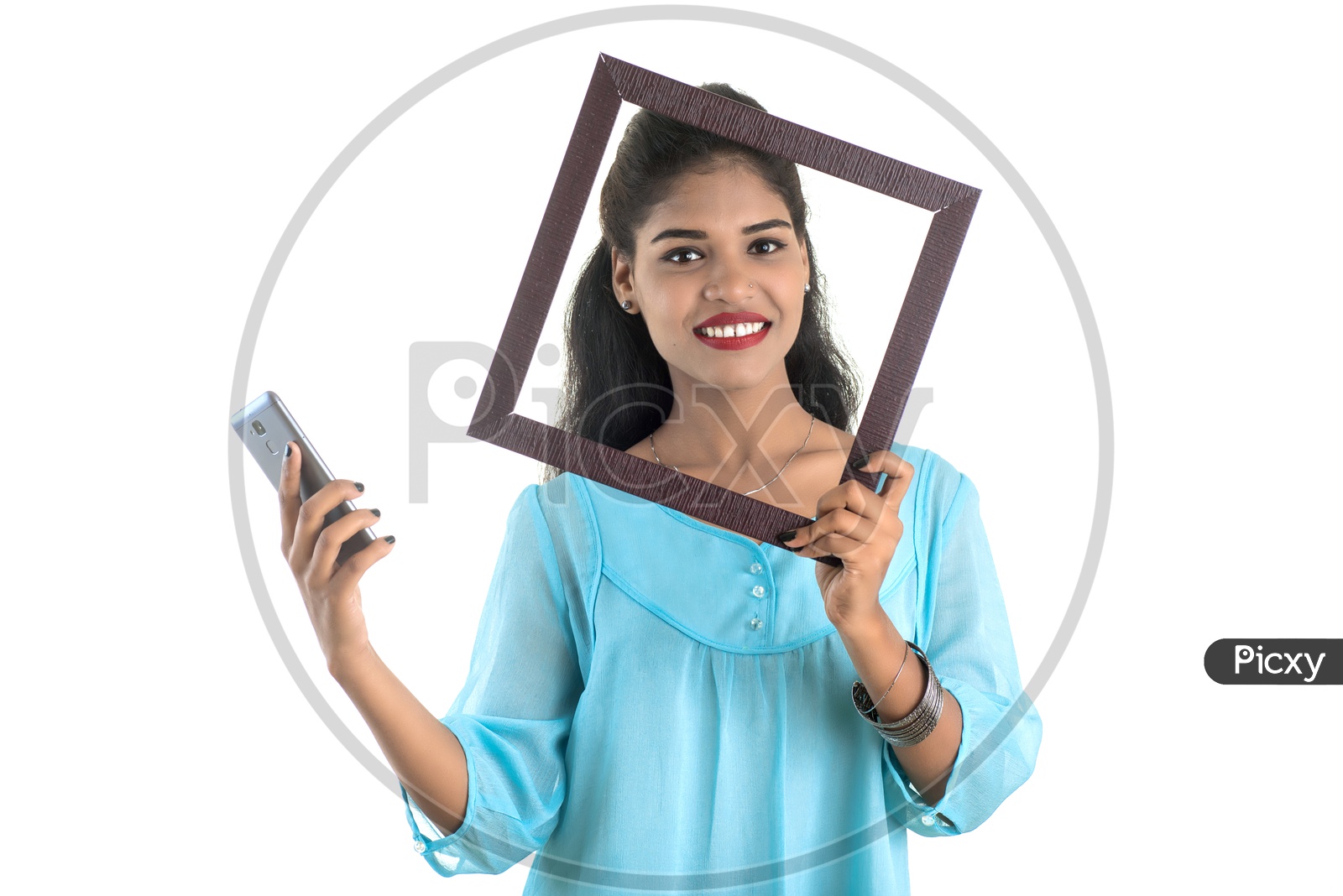 Pretty Young Indian Girl Posing With Photo Frames and a Mobile In Hand On an Isolated White Background