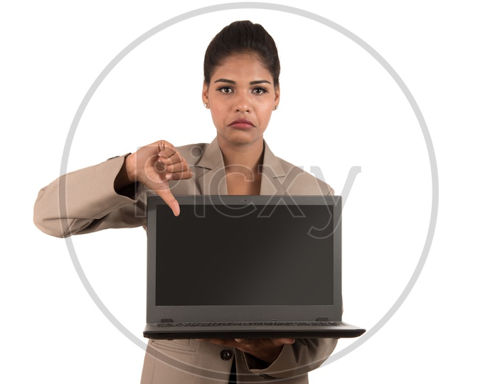 Young Indian business woman holding a laptop giving thumbs down sign