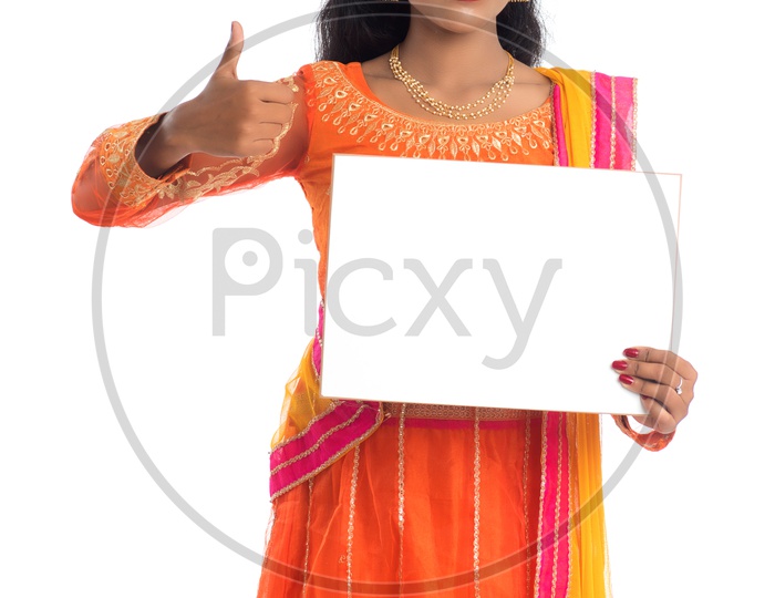 A young pretty Indian woman holding a blank white board or card with a gesture