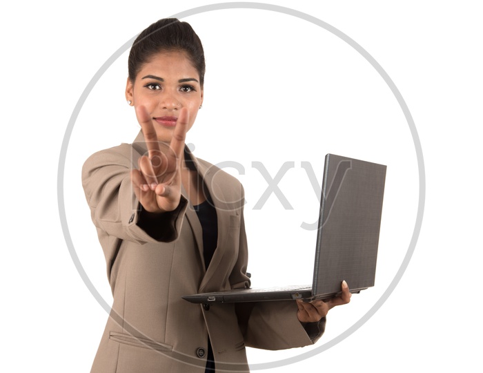 Young Indian business woman with a laptop making peace sign