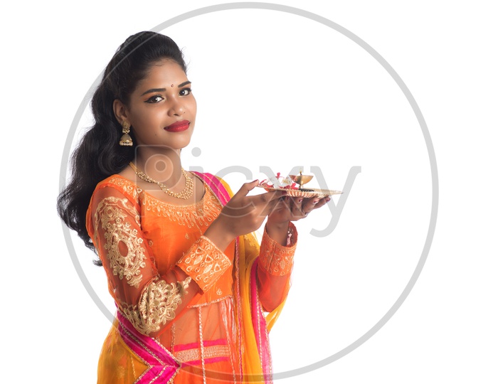 A Young Indian Traditional Woman With Pooja Thali Or Pooja Plates Holding In Hand and Performing Pooja With Smile Face On an Isolated White Background