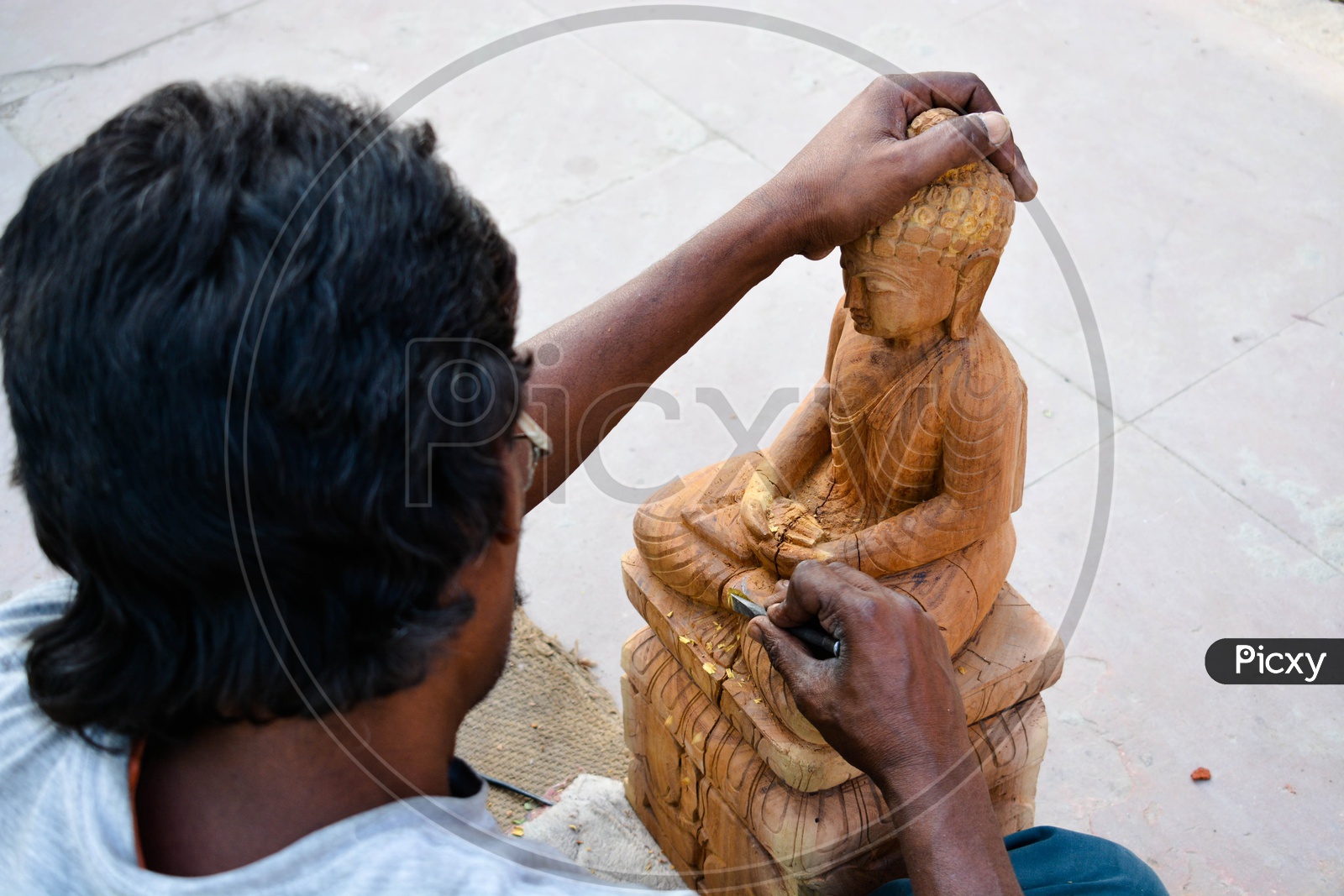 An Artist  Crafting Of Buddha Statue With Wood