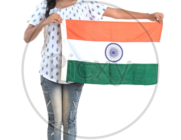 Young Indian Girl Holding Indian National Flag On Hand standing and Posing Over a White background