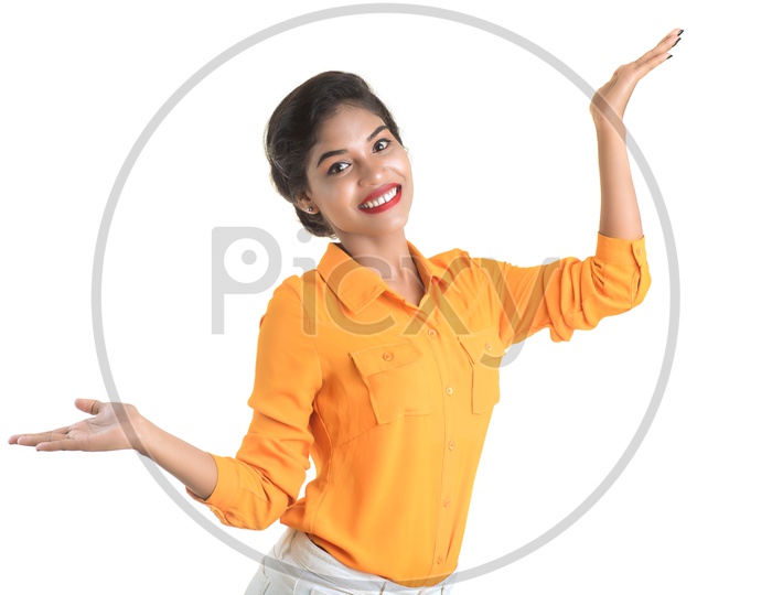 Smiling Indian woman wearing orange shirt and white pant