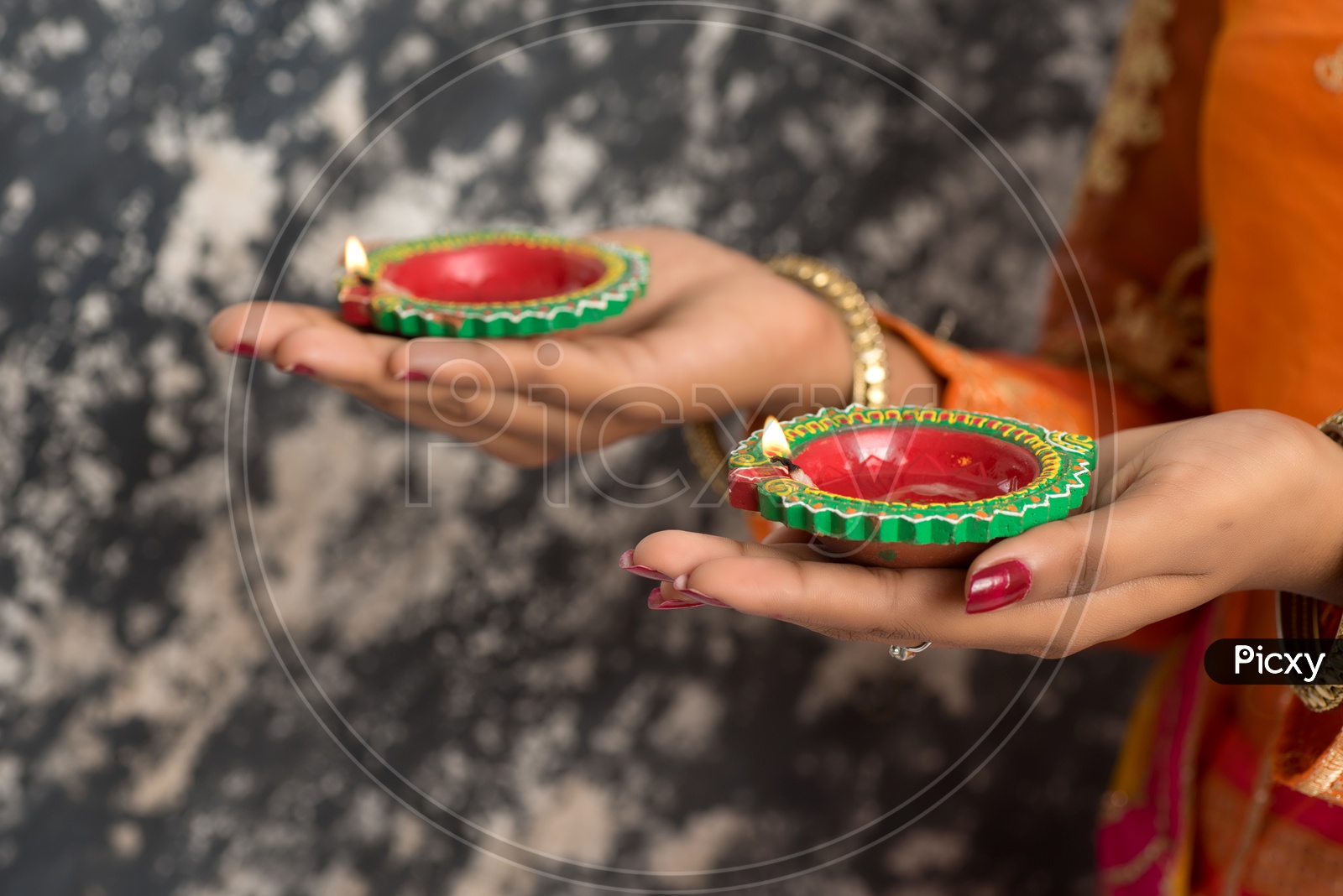 A young Indian woman holding diyas in hand