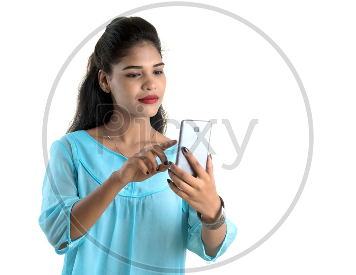 Portrait Of a Young Indian Girl Using Smart Phone  With a Smile Face and Posing On an Isolated White Background