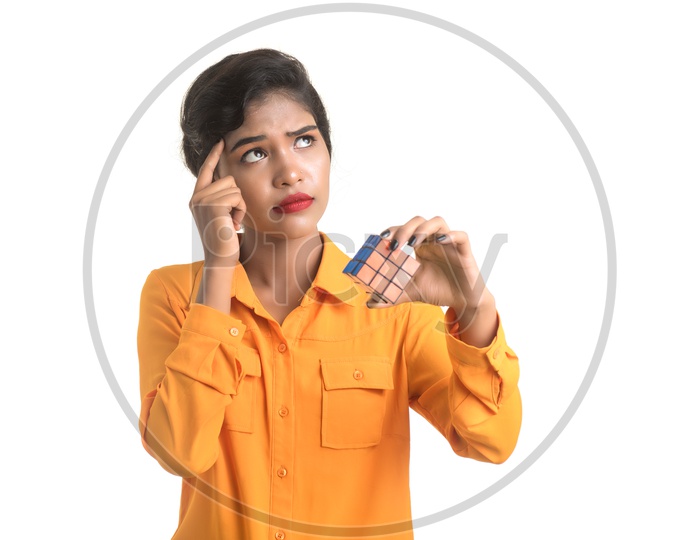 Indian woman wearing orange shirt holding a Rubik's Cube