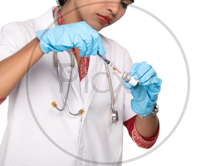 Young Lady Doctor Wearing Surgical Gloves  And Taking medicine Into Syringe   On an Isolated White Background