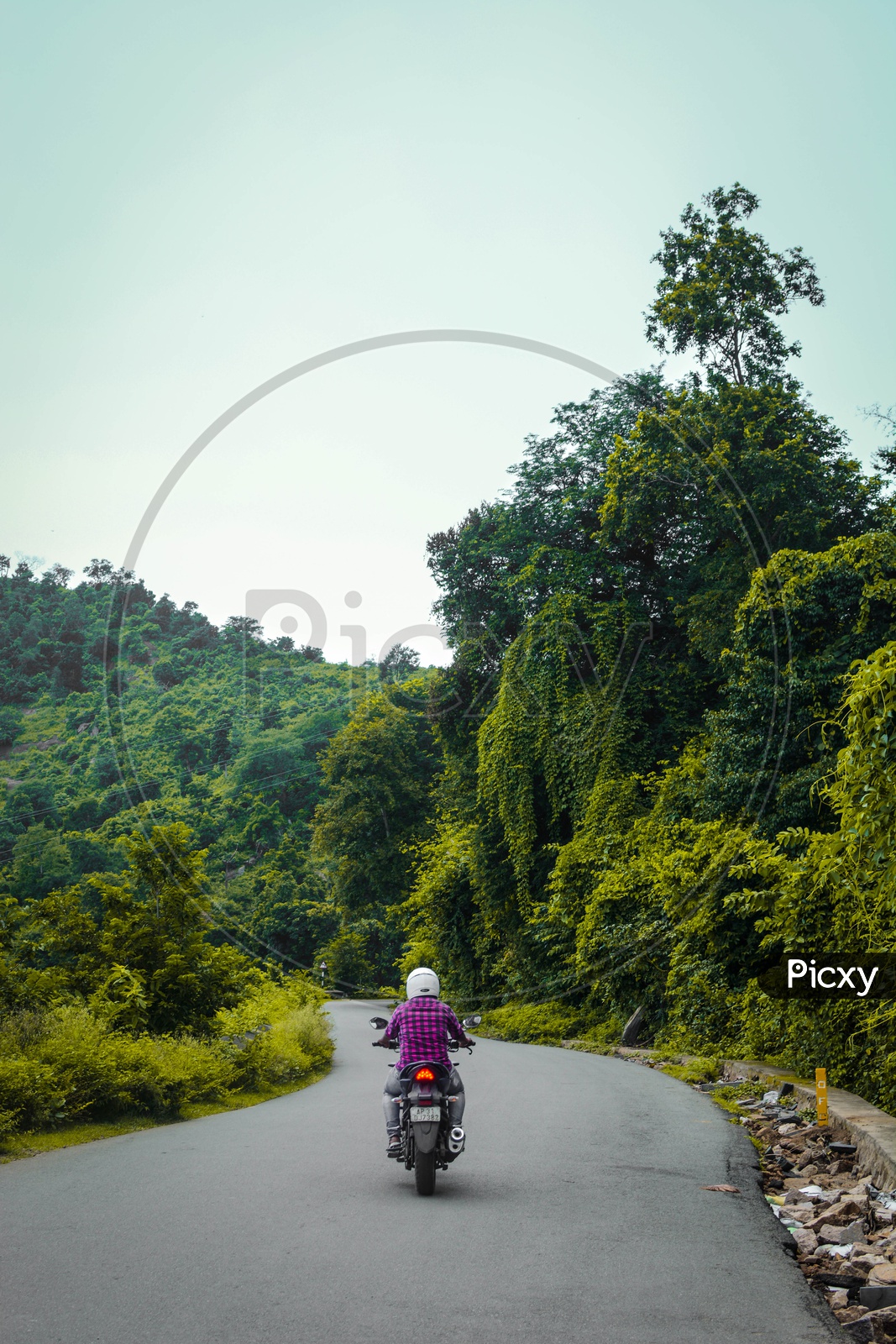 A Man Riding a Bike On The Rural Village Roads