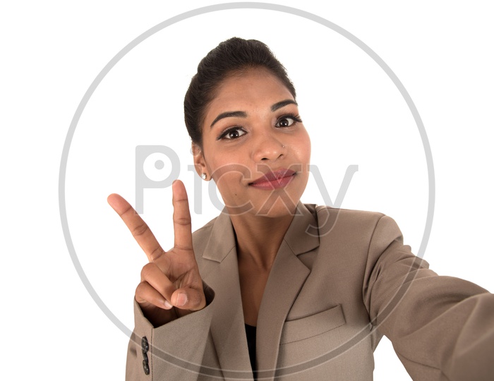 Beautiful young business woman using smartphone to take a selfie