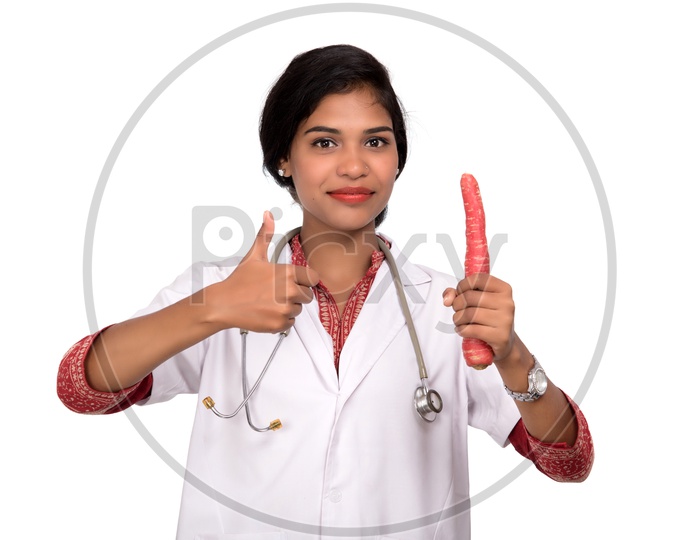 Indian Female Doctor holding carrot making a thumbs up sign