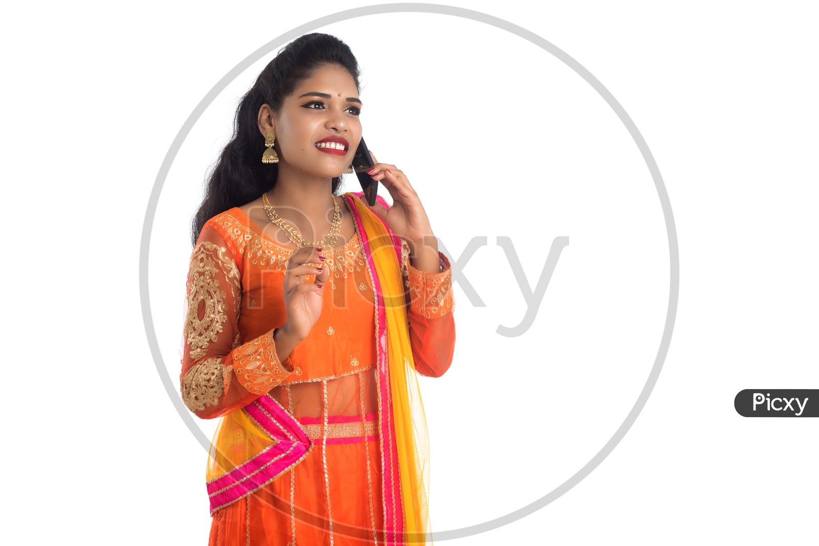A young traditional Indian woman talking on a mobile phone or smart phone