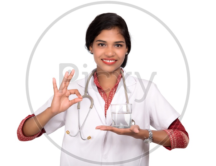 Indian Female Doctor holding a glass of water making super sign