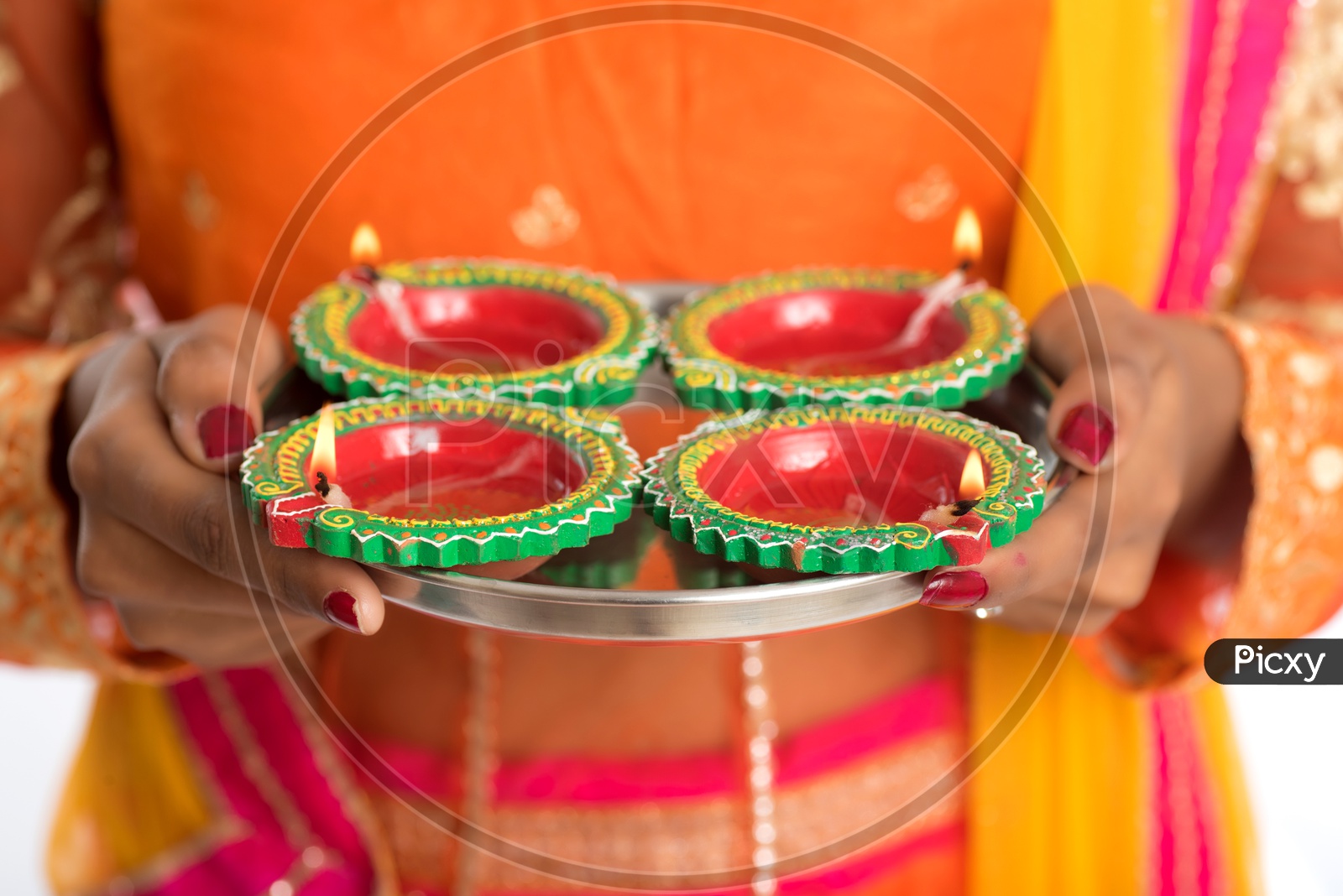 An Indian woman holding diyas in hand