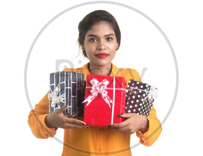 Young Girl Holding Gift Boxes in Hand with Smile On her Face On an Isolated White Background