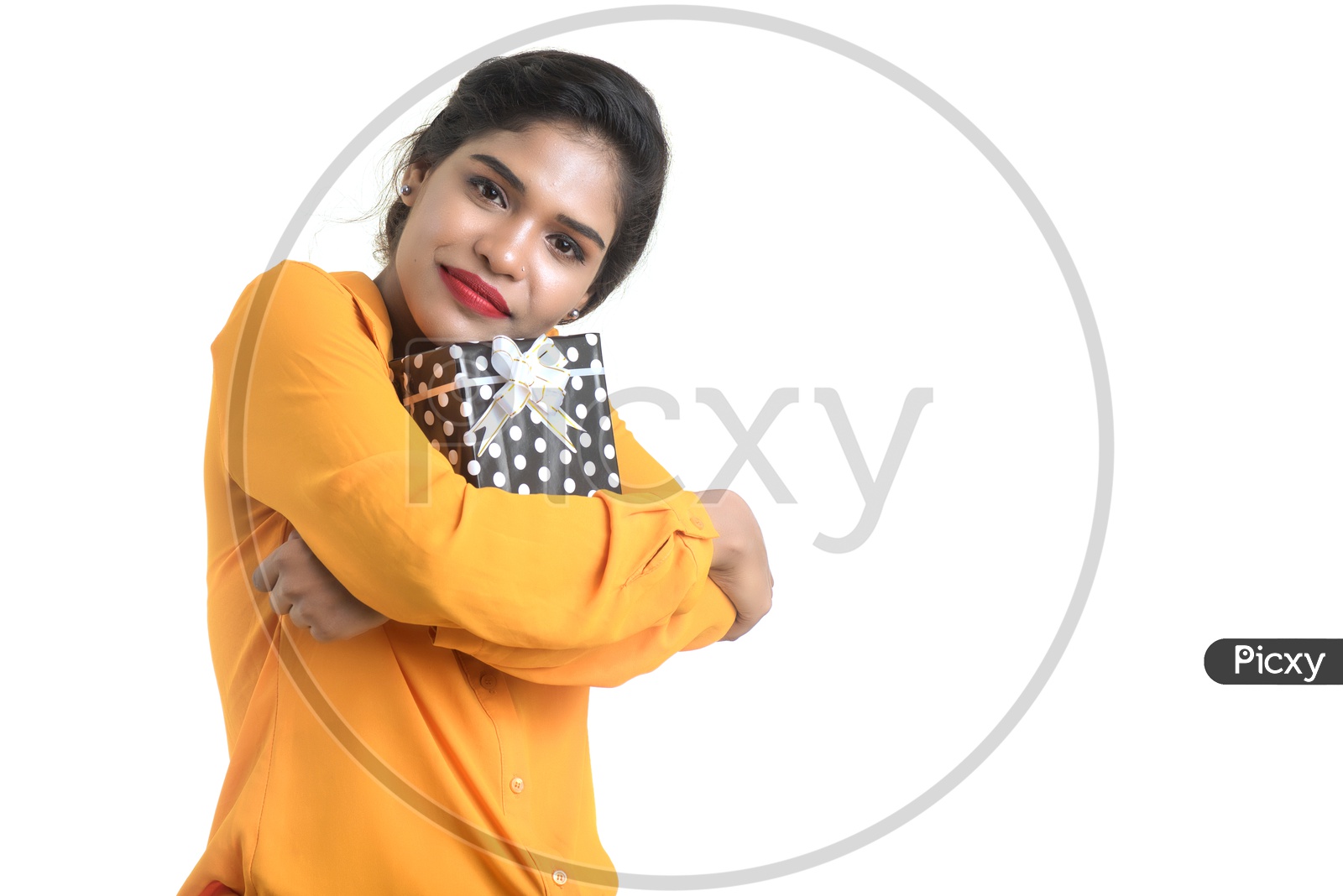Portrait Of a Young Smiling Indian Girl Holding Gift Box On an  Isolated White Background