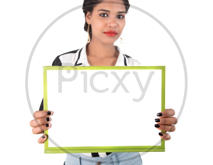 Young Indian Girl Showing The Empty Placard and Pointing The Empty Space on an Isolated White Background