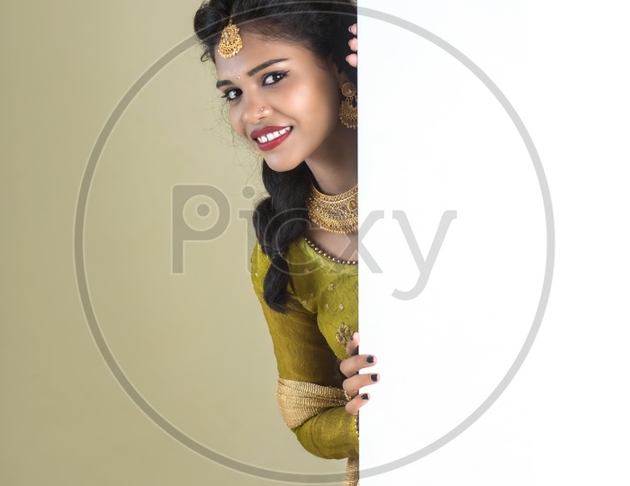 Portrait Of a Beautiful Young woman In Elegant Look and Posing  At a Empty Space Board Over White Background