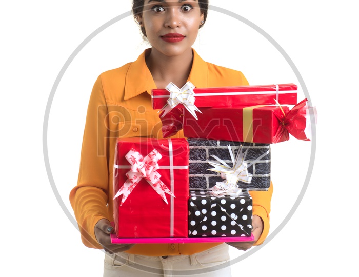 Young Indian Girl Holding Gift Boxes In Hand and Posing Over an Isolated White Background
