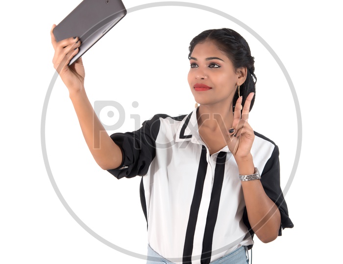 Pretty Young Indian Girl Taking Selfies In Smart Phone On an Isolated White Background