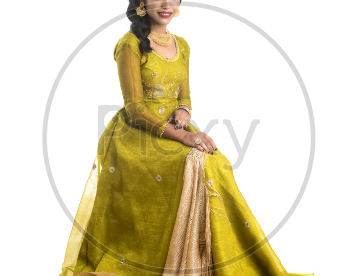 Portrait Of a Traditional  Beautiful Indian woman In Elegant Look Sitting and Posing Over White Background