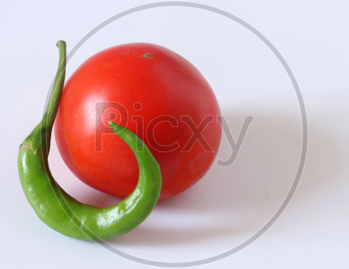 Green chilli and tomato isolated on a white background