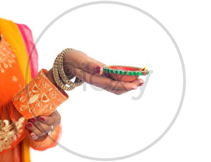 A Young Indian Girl Holding Diwali Dia or Festival Dias In Hand on an Isolated White Background