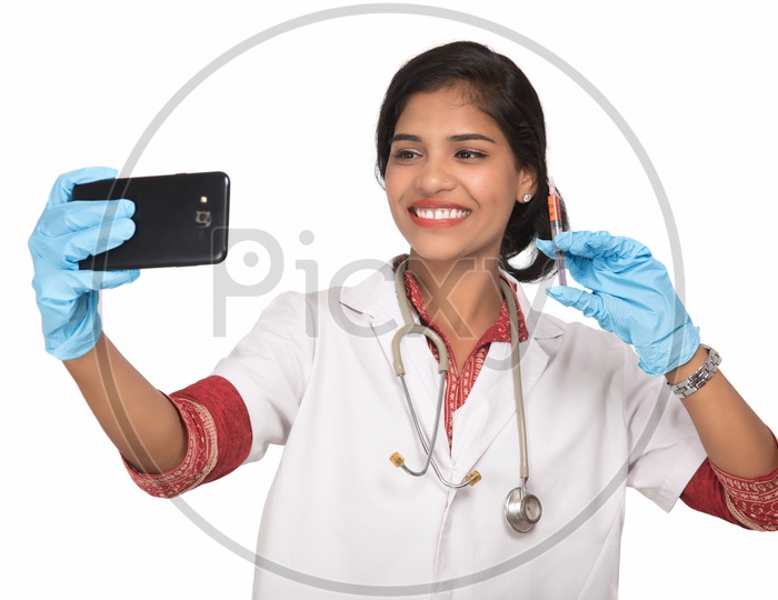 Indian Female Doctor taking selfie with a loaded syringe