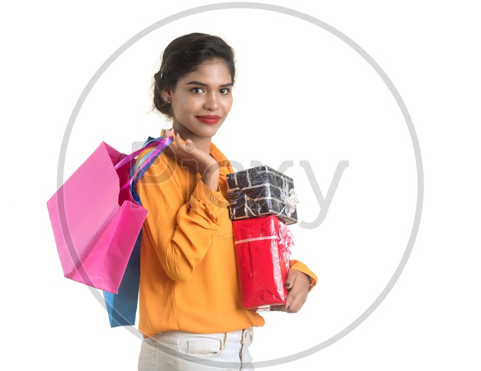 Young Girl Holding Gift Boxes and Bags in Hand  with Smile On her Face On an Isolated White Background