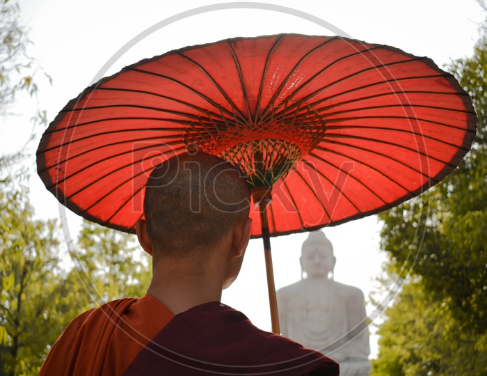 Buddhist Monks With Red Umbrella