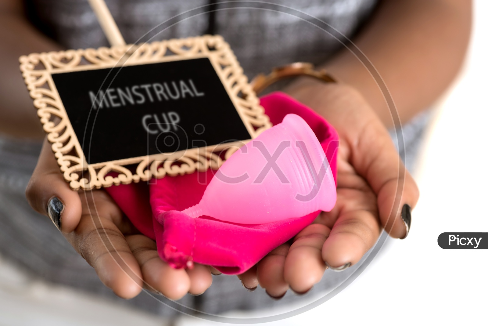 Menstrual Cup and a pouch with a sign board in the hands of a Indian Woman