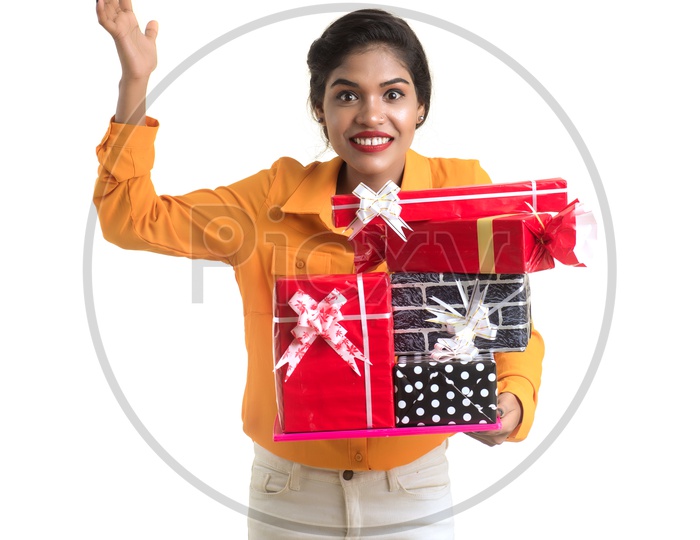 A Happy Young Beautiful Indian Girl Holding Gift Box in Hand on an Isolated White Background