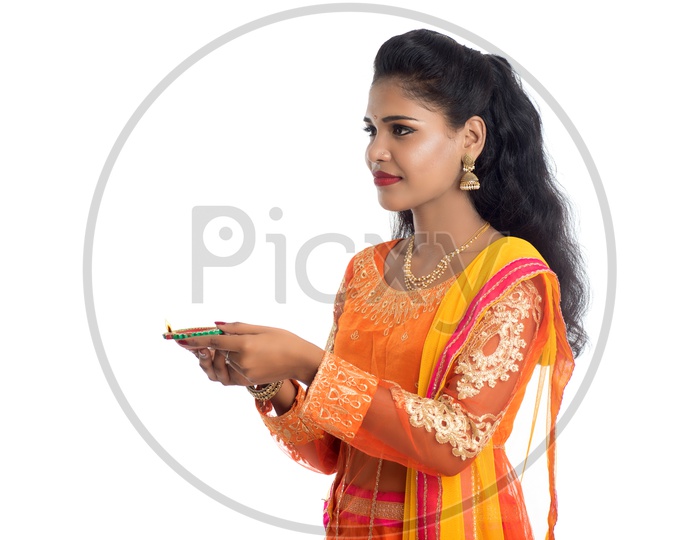 A young traditional smiling pretty Indian woman holding diya in hand
