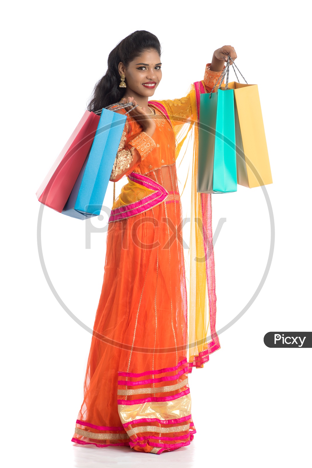 Young Indian Traditional  Girl Holding Shopping Bags Or Festival Shopping Bags And Posing On an Isolated White Background