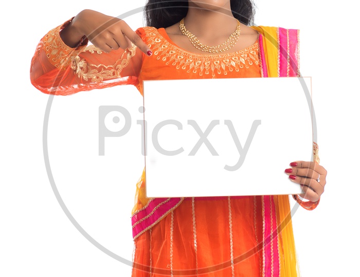A young pretty Indian woman holding a blank white board or card
