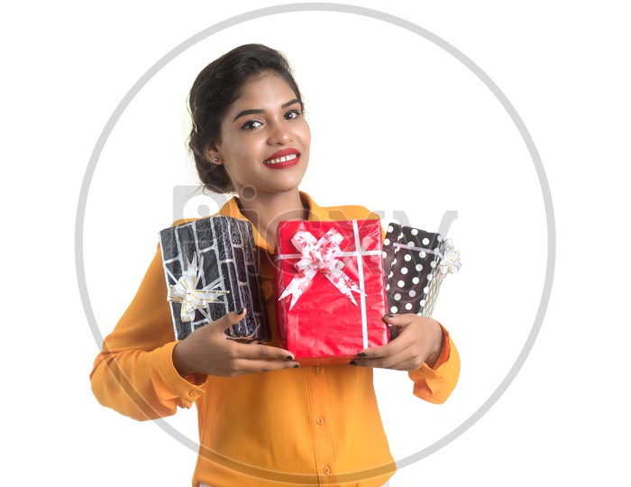A Happy Young  Indian Girl Holding Gift Boxes in Hand And With a Smile Face on an Isolated White Background
