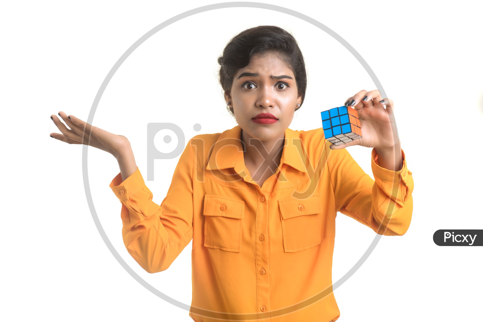 Young Beautiful Girl With a Puzzled Expression On Her Face and Holding Rubik's cube in hand on an isolated White Background